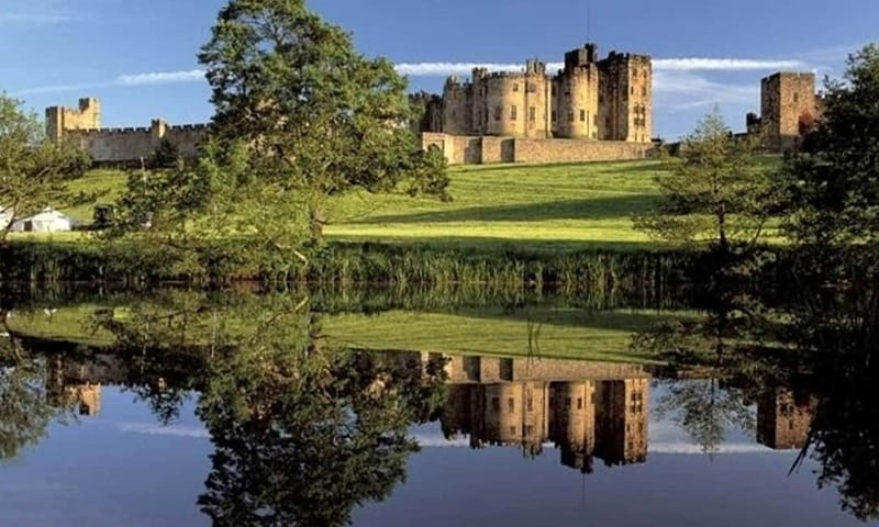 Edinburgh: Harry Potter and English Castles Tour in Spanish - Bamburgh Castle and the beach below